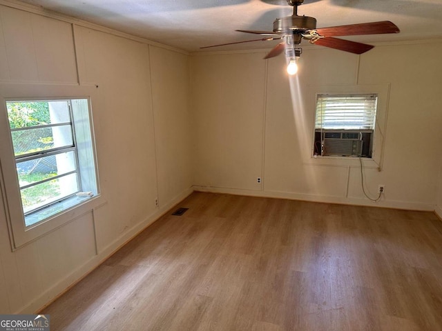 unfurnished room featuring ceiling fan, cooling unit, a textured ceiling, light hardwood / wood-style flooring, and crown molding