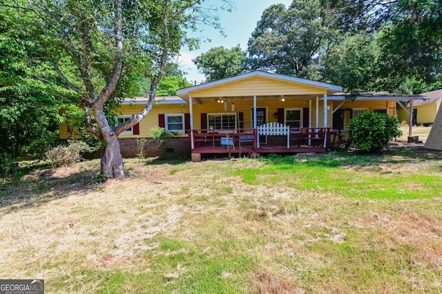 back of property with a wooden deck and a yard