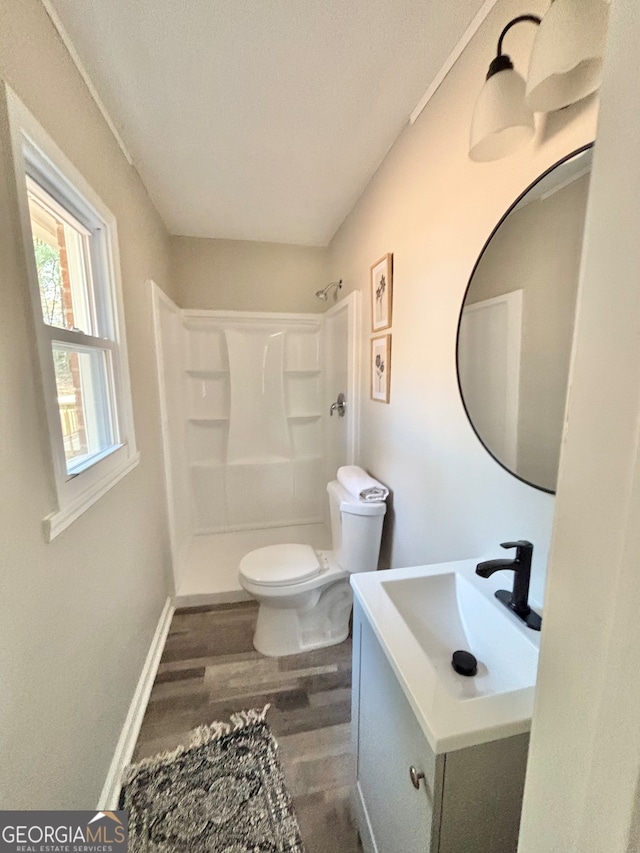 bathroom featuring walk in shower, toilet, vanity, and hardwood / wood-style flooring