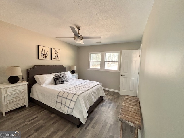 bedroom with dark hardwood / wood-style floors, ceiling fan, and a textured ceiling