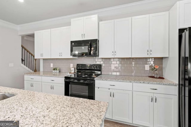 kitchen with backsplash, black appliances, and white cabinetry