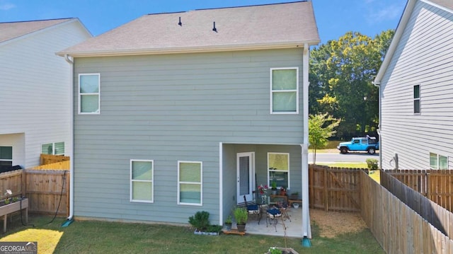 rear view of property featuring a patio area and a yard