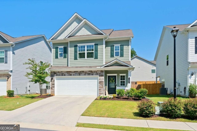 craftsman-style house with cooling unit, a garage, and a front lawn