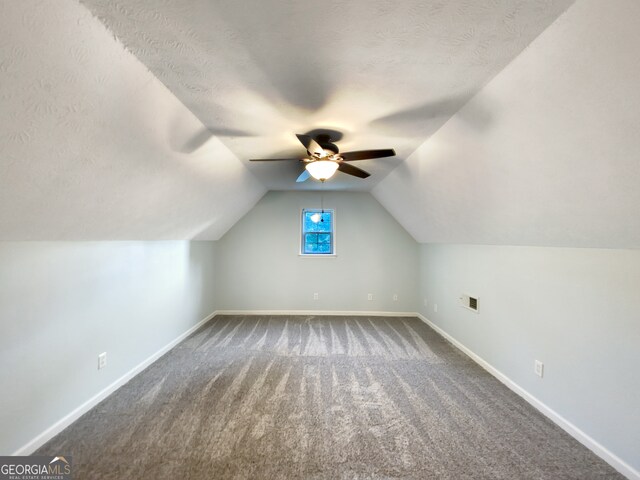 additional living space with vaulted ceiling, a textured ceiling, ceiling fan, and carpet floors