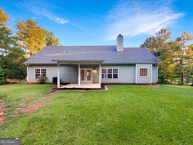 back of house featuring a yard and french doors