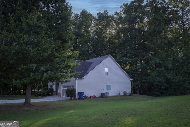 property exterior at dusk featuring a yard