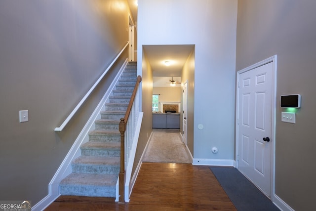 foyer featuring ceiling fan, light wood-type flooring, and a high ceiling