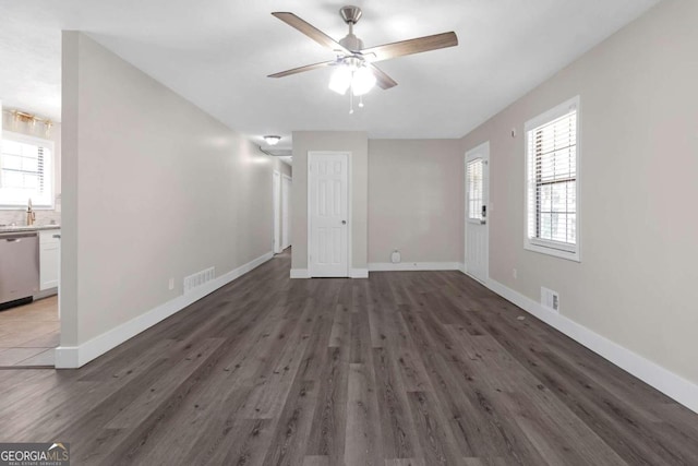 empty room with ceiling fan, sink, and dark hardwood / wood-style flooring