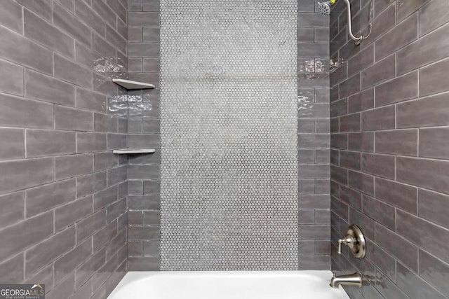 bathroom with tiled shower / bath combo