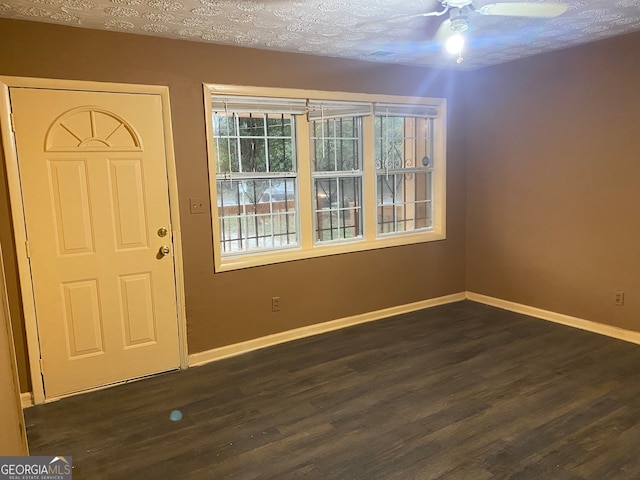 foyer entrance with dark wood-type flooring, ceiling fan, and a textured ceiling