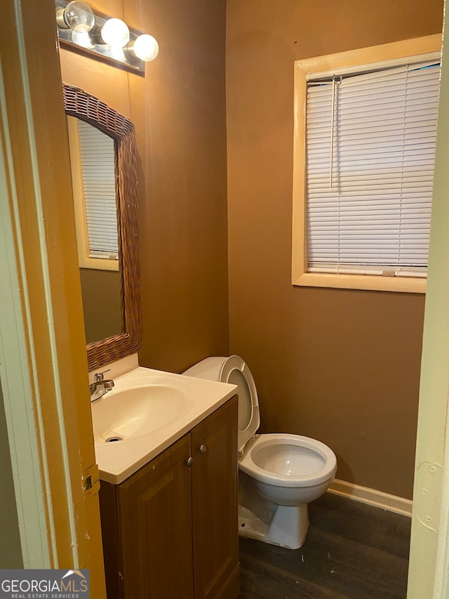 bathroom with hardwood / wood-style floors, vanity, and toilet