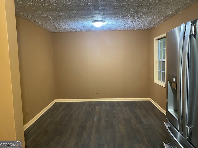 empty room featuring dark hardwood / wood-style floors and a textured ceiling