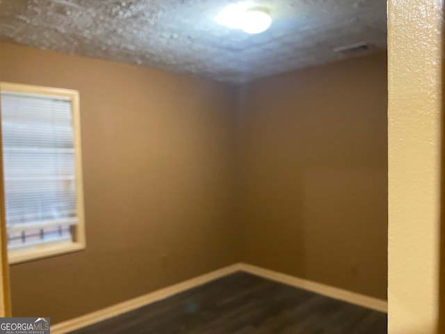 spare room featuring dark wood-type flooring