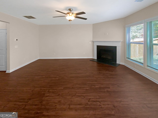 unfurnished living room with dark hardwood / wood-style flooring and ceiling fan