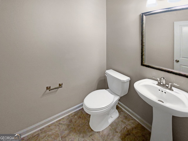 bathroom featuring toilet, sink, and tile patterned floors