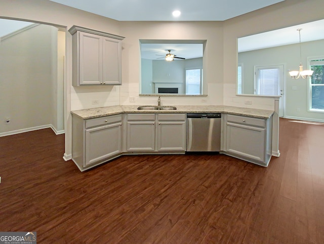 kitchen with stainless steel dishwasher, a healthy amount of sunlight, ceiling fan with notable chandelier, and dark hardwood / wood-style flooring