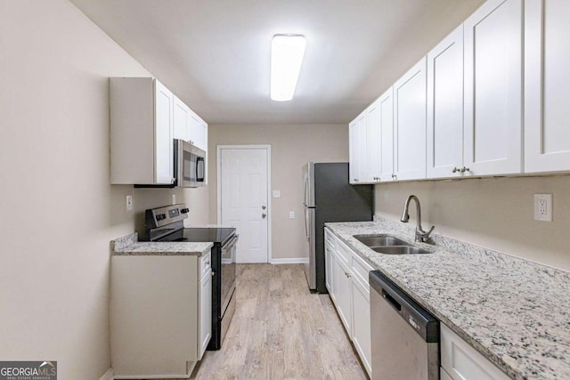 kitchen with white cabinetry, sink, light wood-type flooring, and appliances with stainless steel finishes