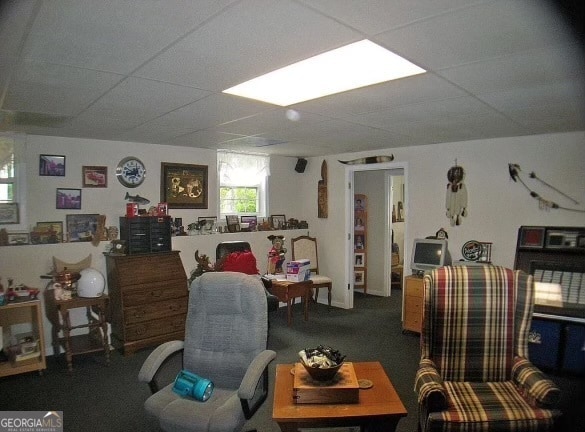 carpeted living room with a paneled ceiling