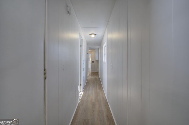 hallway with light wood-style flooring and baseboards