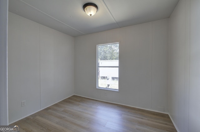 empty room with a decorative wall and wood finished floors