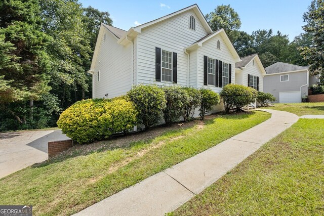 view of home's exterior featuring a lawn and a garage