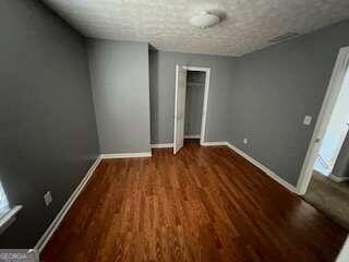 interior space featuring dark wood-type flooring and a textured ceiling