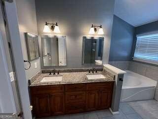 bathroom with tile patterned flooring, vanity, and a bathtub