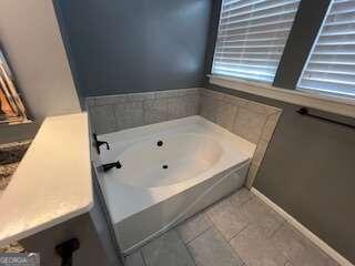 bathroom featuring tile patterned flooring and a washtub