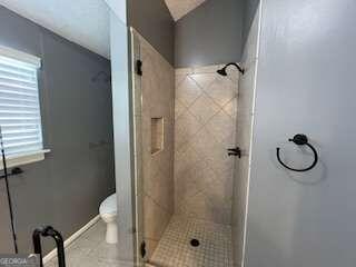 bathroom with toilet and walk in shower