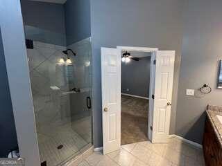 bathroom featuring vanity, ceiling fan, a shower with shower door, and tile patterned floors