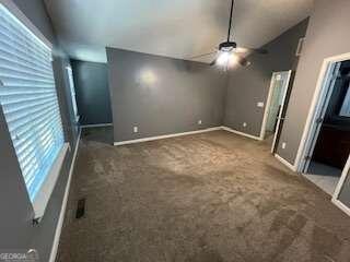 carpeted spare room featuring ceiling fan