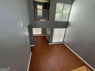 unfurnished living room featuring a wealth of natural light and dark hardwood / wood-style floors