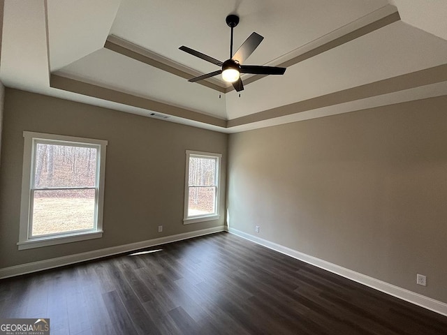 unfurnished room featuring dark hardwood / wood-style flooring, a raised ceiling, and ceiling fan