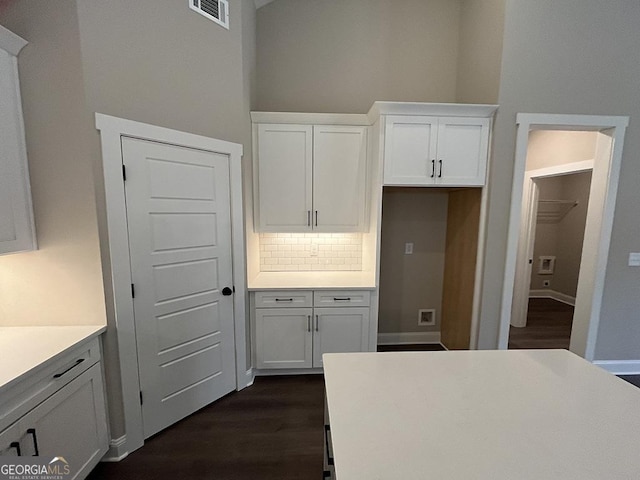 kitchen featuring white cabinetry, backsplash, and dark hardwood / wood-style flooring