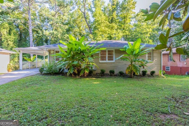 ranch-style house featuring a front lawn and a carport