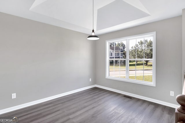 spare room with visible vents, baseboards, and dark wood-style flooring