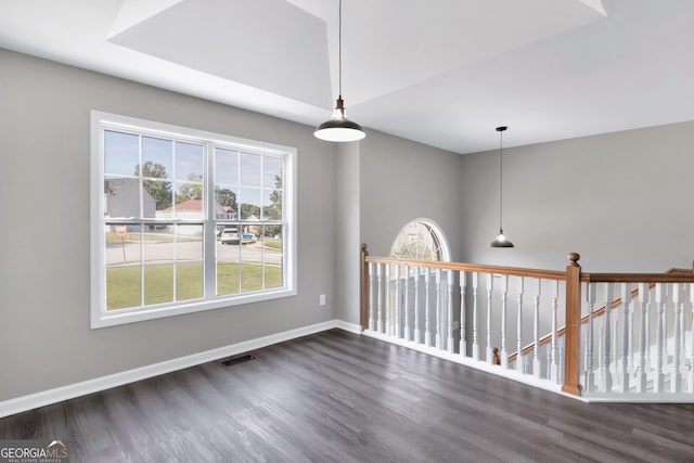 unfurnished room with dark wood-style floors, visible vents, and baseboards