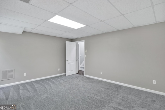 unfurnished room with baseboards, visible vents, a drop ceiling, stairway, and carpet flooring