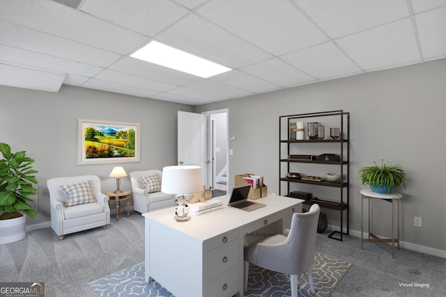 carpeted home office featuring a drop ceiling and baseboards