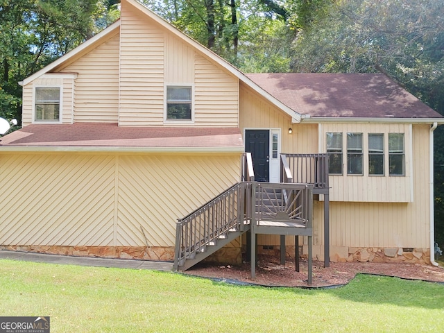 rear view of house with a yard and a deck