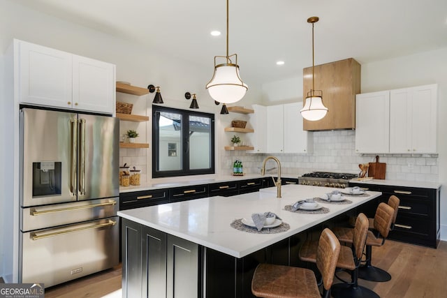 kitchen with dark cabinetry, open shelves, light countertops, white cabinets, and stainless steel refrigerator with ice dispenser