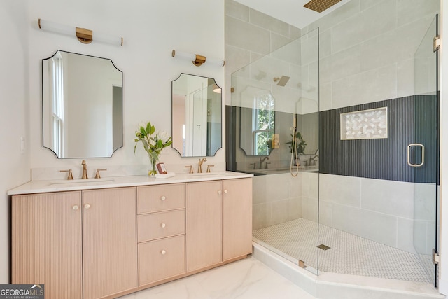 full bathroom featuring a sink, marble finish floor, a stall shower, and double vanity