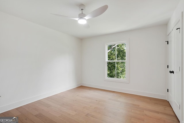 spare room with light wood-type flooring, baseboards, and ceiling fan