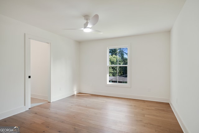 empty room with ceiling fan and light hardwood / wood-style floors