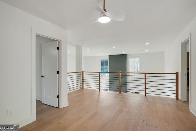 empty room with ceiling fan and light hardwood / wood-style floors