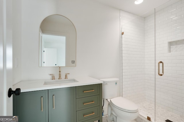 bathroom featuring toilet, a stall shower, and vanity