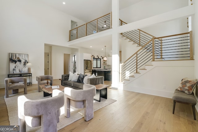 living room featuring light hardwood / wood-style floors and a high ceiling