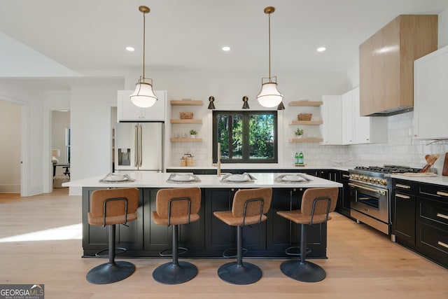 kitchen with stainless steel stove, light countertops, fridge with ice dispenser, and open shelves