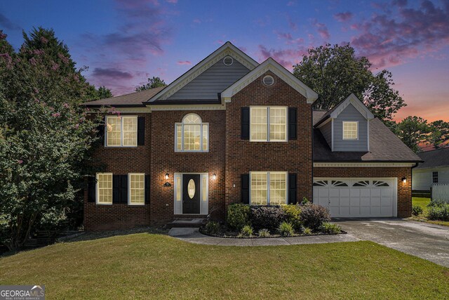 view of front of property featuring a yard and a garage