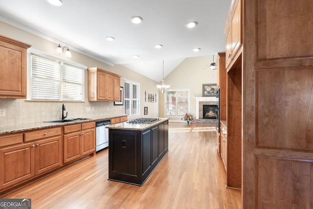 kitchen featuring light stone countertops, sink, a kitchen island, and appliances with stainless steel finishes